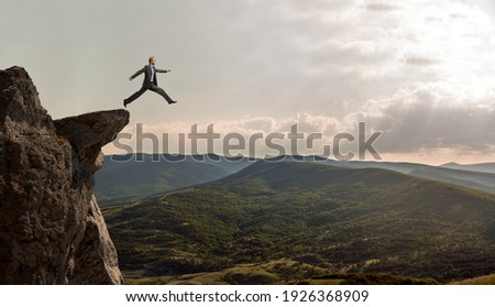 businessman jumps over the abyss, business concept Royalty-Free Stock Photo #1926368909