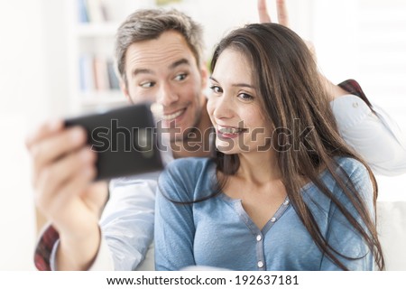 cheerful couple taking a humorous selfie with a smartphone