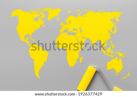 World map drawn paint yellow color on a gray background. Minimalistic composition with colors of the year 2021 - Illuminating Yellow and Ultimate Gray
