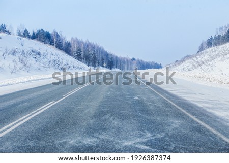 Winter snowy empty highway in a blizzard Royalty-Free Stock Photo #1926387374