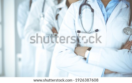 Group of modern doctors standing as a team with arms crossed in hospital office. Medical help, insurance in health care, best desease treatment and medicine concept Royalty-Free Stock Photo #1926387608