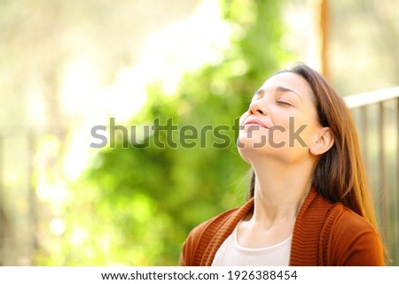 Relaxed woman breathing fresh air in a garden a sunny day at home Royalty-Free Stock Photo #1926388454
