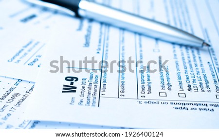 Form W-9, Request for Taxpayer Identification Number and Certification with pen Royalty-Free Stock Photo #1926400124