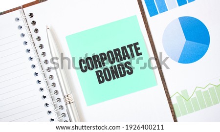 Green card on the white notepad. Text CORPORATE BONDS. Business concept