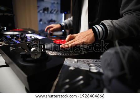 Hip hop dj scratching vinyl records. Professional disc jockey mixes musical tracks with analog turntables and sound mixer