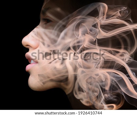 A portrait of a young  hispanic woman's profile against dark background combined with a photo of fume swirls in a double exposure technique