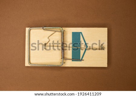 wooden mousetrap on a brown background. Concept: danger deception