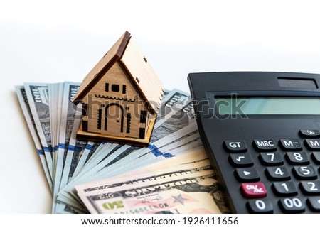 The model of the house stands on the money. Planning savings money to buy a home, mortgage and real estate investment, saving for a buy house. Royalty-Free Stock Photo #1926411656