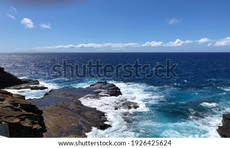 Beautiful view of Oahu's oceanside with calming waves and low tide, deep blue ocean views, fresh air, blue sky.