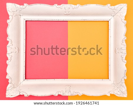 White vintage wooden frame on pink and yellow background, free space inside of frame for text or design. 