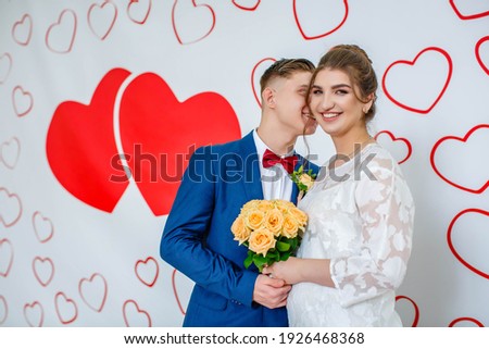 newlyweds take pictures at the photo zone with painted hearts