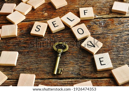 A close up image of wooden alphabet blocks spelling out the inspirational message of self love.