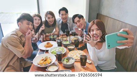 asian young six friends taking selfie in restaurant happily
