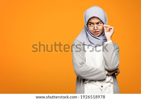 Portrait of beautiful Asian woman holding eyeglasses and look serious