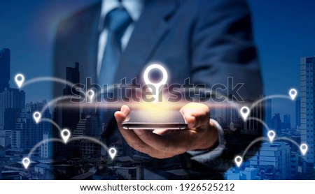 Businessman use internet network on mobile phone find location in the city by GPS Navigator Map. Man hold smart Phone connect to GPS location icon show global business, direction, travel, 5G concept. Royalty-Free Stock Photo #1926525212