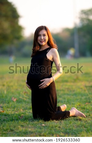 Beautiful portrait healthy pregnant woman in park.