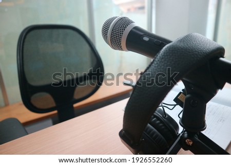 Technology and audio equipment concept - headphones and microphone at home office or recording studio
