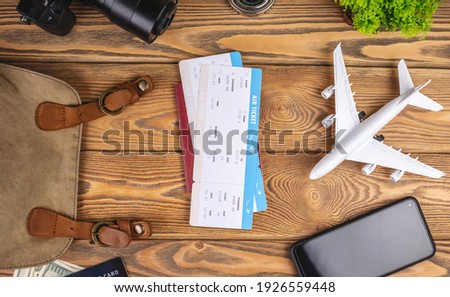 Layout of airplane travel accessories on a wooden background. Top view.