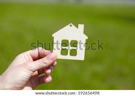 hand with wood house