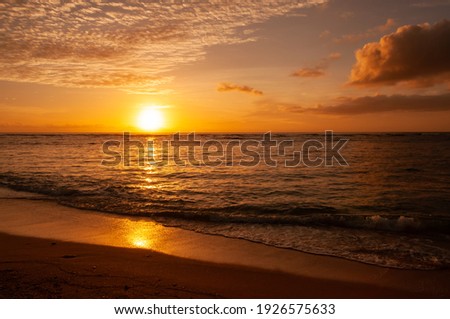Vibrant sunset descending on the horizon, sea in golden colors, small waves gently touching the sands, amazing clouds on sky. Iriomote Island. Royalty-Free Stock Photo #1926575633