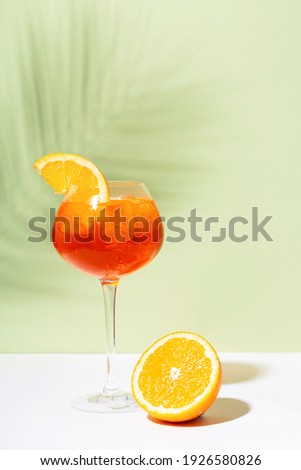 Aperol spritz on white and green background.  Hard light and shadow Royalty-Free Stock Photo #1926580826