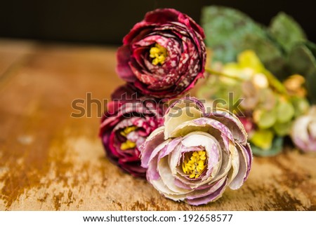 Beautiful rose of artificial flowers on wood