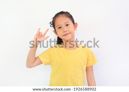 Smiling Asian little girl showing finger I love you symbol sign language isolated on white background