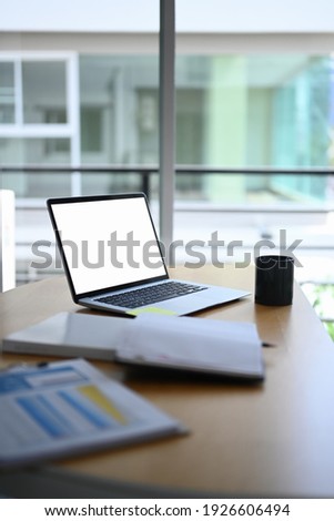 Computer laptop, coffee cup and document on accountant workplace.