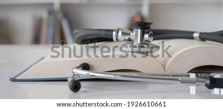 stethoscope on stack of medical guide book for doctor learning treatment at hospital. Royalty-Free Stock Photo #1926610661