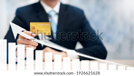 Businessman holding credit card and market graph on the Internet on the laptop computer with credit card, online payment, shopping online, e-commerce, internet banking, spending money concept.