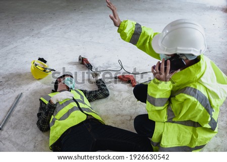 Work accidents of worker in workplace at construction site area and Unconscious with colleague motion and call to the safety officer for rescue and Life-saving. Selection focus on an Injured person. Royalty-Free Stock Photo #1926630542