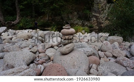 stucked balanced stones and rocks to calm down and meditate on a lake with a pebbles beach closeup