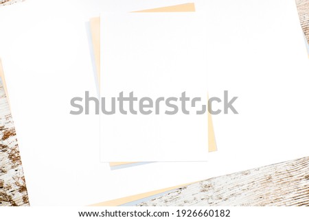 Colored paper sheets with copy space on a wooden table. Publicity concept