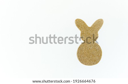 Easter golden glitter bunny on the white background. Minimalist Easter concept.