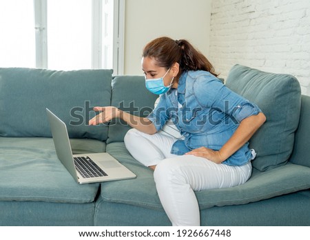 Stressed woman working from home on laptop looking worried, tired and overwhelmed. Exhausted female on zoom during social distancing. Mental health, business and coronavirus lockdown.