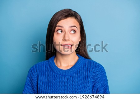 Portrait of young lovely pretty unsure uncertain doubtful girl bite lips look copyspace isolated on blue color background Royalty-Free Stock Photo #1926674894