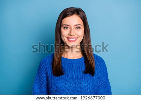 Portrait of young lovely pretty smiling cheerful positive girl wearing knitted blue jumper isolated on blue color background