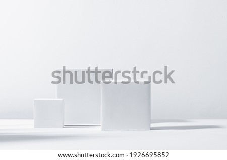 White square podiums in sunlight with shadow on white background. Trend fashion showcase for cosmetic products, goods, shoes, bags, watches. Royalty-Free Stock Photo #1926695852