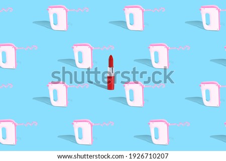 Creative idea. Lipstick and kitchen mixer on a blue uniform background. Pattern. Fashion or homework.