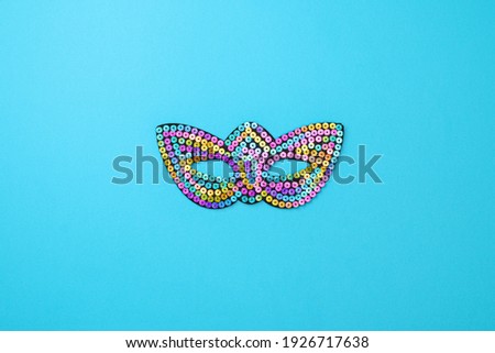 Multicolored theatrical mask on a blue background. The concept of the Venetian carnival, celebration, carnaval, mardi gras, purim.