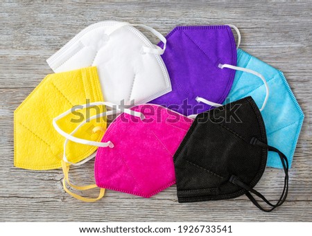 Colorful FFP2 masks on a wooden background Royalty-Free Stock Photo #1926733541