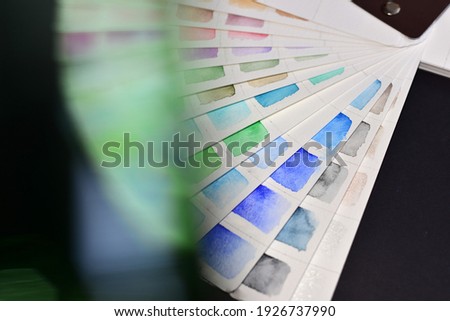 Color palette in blue and green colors, on a black background. In the foreground, blurry colored spots.