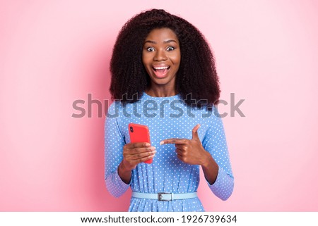 Photo of promoter lady hold phone direct finger open mouth wear blue dotted dress isolated pink color background