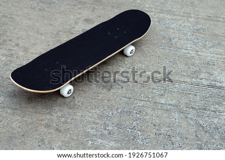 Black skateboard on cement ground. Copy space
