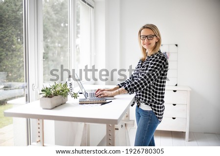Woman working at a standing desk in office