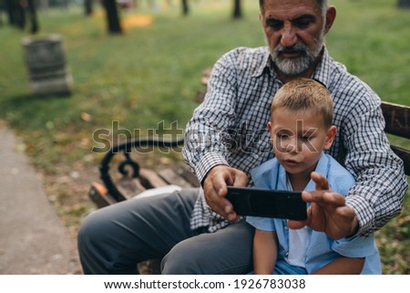 grandfather and grandson enjoying time together on public park