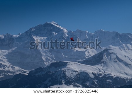 Landscape view of the snowy swiss Alpes, with paragliders in the foreground, shot in Beatenberg, Niederhorn,Switzerland