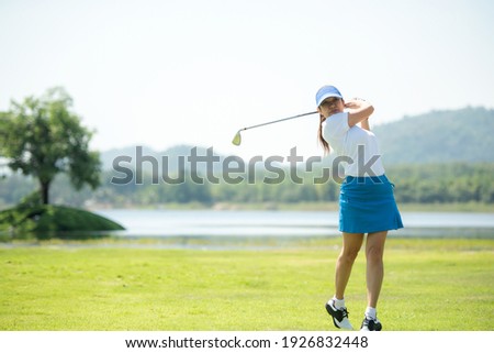 Golfer sport course golf ball fairway. People lifestyle woman playing game golf and hitting go on green grass river and mountain background.  Asia female player game shot in summer.  Healthy  Sport