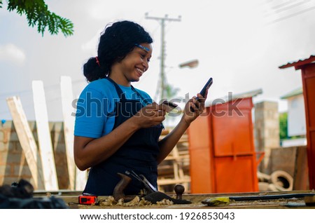 young pretty african lady feeling overexcited about what she saw on her cellphone