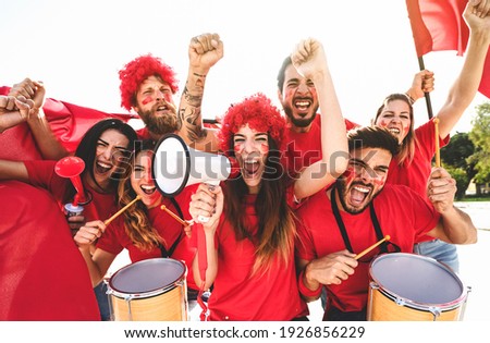 Football fans watching soccer match event at stadium - Young people having fun supporting favorite club - Sport entertainment concept  Royalty-Free Stock Photo #1926856229